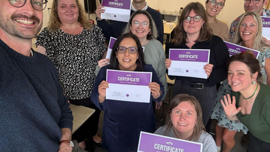 An image of a group of people facing the camera, holding up certificates.